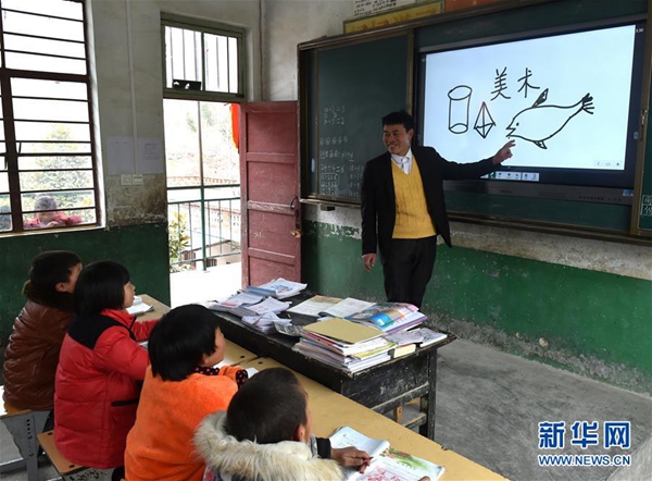 张玉滚在利用多媒体设备给学生们上美术课（3月20日摄）。新华社记者 李嘉南 摄